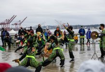 Waterfront Seattle to Kick Off 2023 Events with Lunar New Year Dancers in green and black on a wet pier.