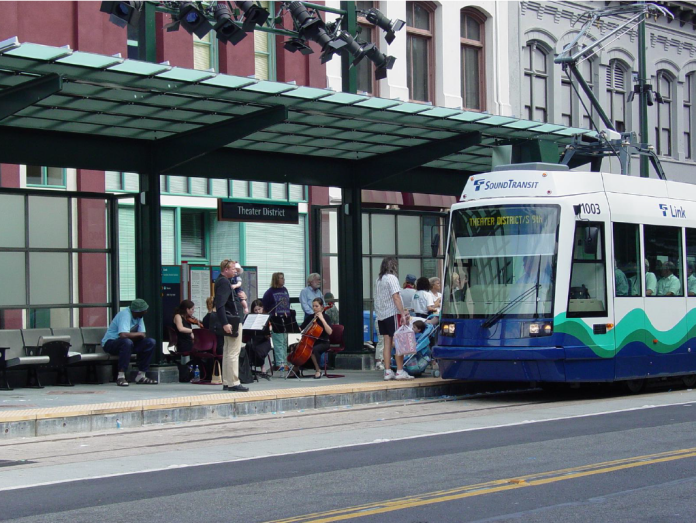 Tacoma Link Theater Station Opening Day A light rail train approaches a station where a string quartet plays.