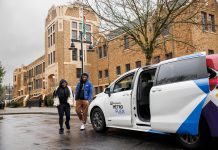 Metro Flex Launching In Early March, Replacing Other King County Microtransit Options White van with passenger door open waits for riders in front of a brick building.