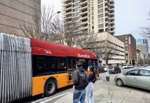 Bus Service Needs Investment Rather Than Neglect Two pedestrians and a car watch the RapidRide H bus go by.