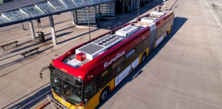 A red and yellow RapidRide bus waits at a stop at an off-street transit center
