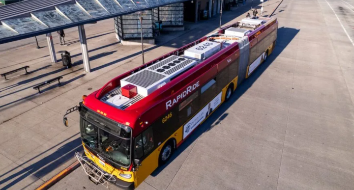 A red and yellow RapidRide bus waits at a stop at an off-street transit center