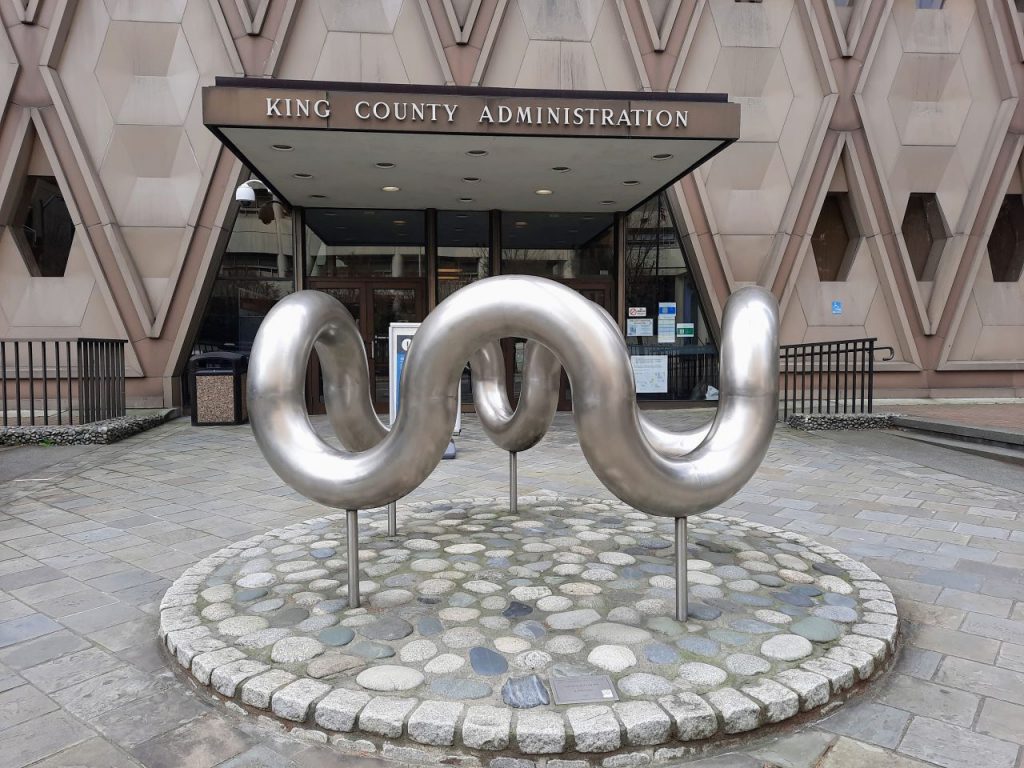 A silver metal worm wheel sculpture thing is at the entrance.