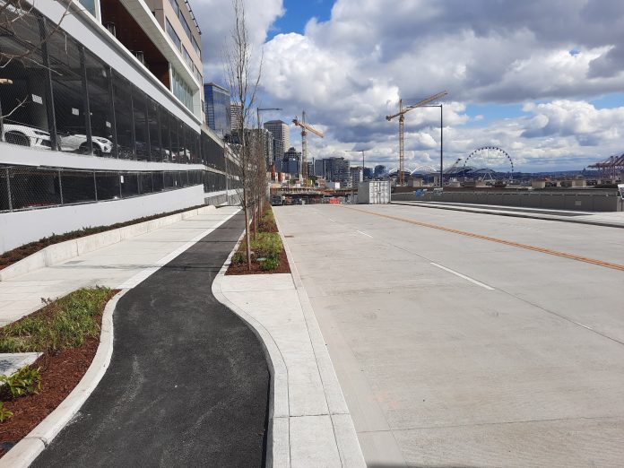 A four lane road with a raise bike lane and sidewalk