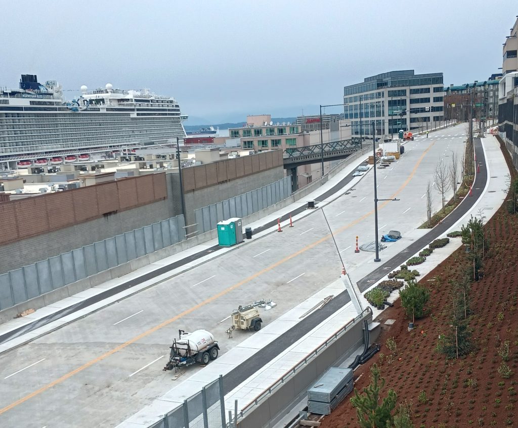 A quiet Elliott Way during final touches of construction with a cruise ship docked nearby at Terminal 66.
