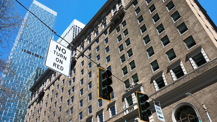 A no turn on red sign in downtown Seattle with Rainier Tower building in the background