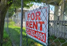 Dueling Tenant Rights Measures Square Off in Tacoma Chainlink fence with a for rent sign for a house.