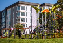 2023 Park Index Ranks Seattle Eighth in Nation play equipment with children and an apartment building in the background