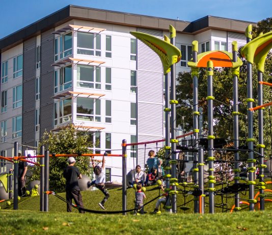 2023 Park Index Ranks Seattle Eighth in Nation play equipment with children and an apartment building in the background