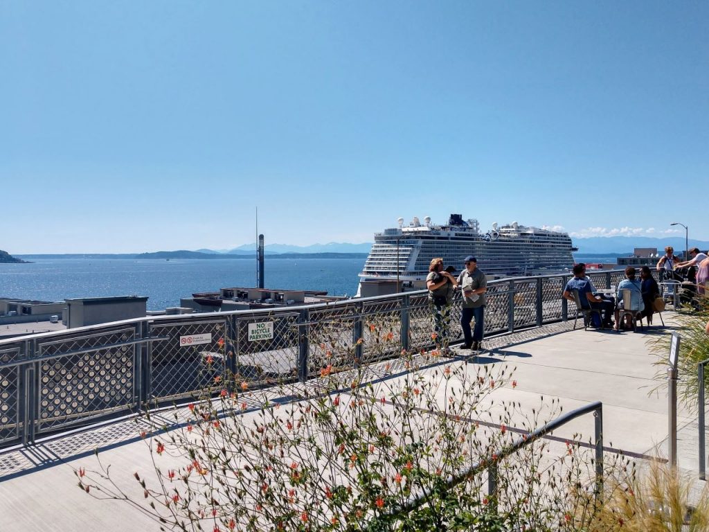 People enjoy the view from the overlook at Pike Place Market on a sunny summer day.