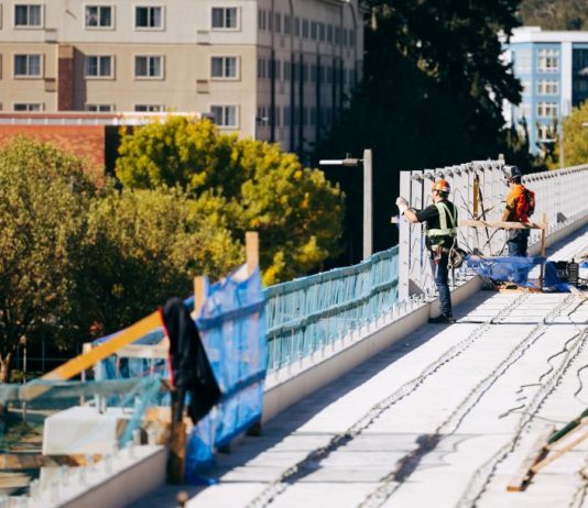 Board Worries Sound Transit Is Minimizing Role of Planned Megaproject Whiz Hires Midrise apartments arer in the background behind the elevated guideway in Redmond.