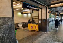 Sound Transit Restores Downtown Light Rail Service People walk by the station entrance, which includes a yellow barricade for a closed elevator.