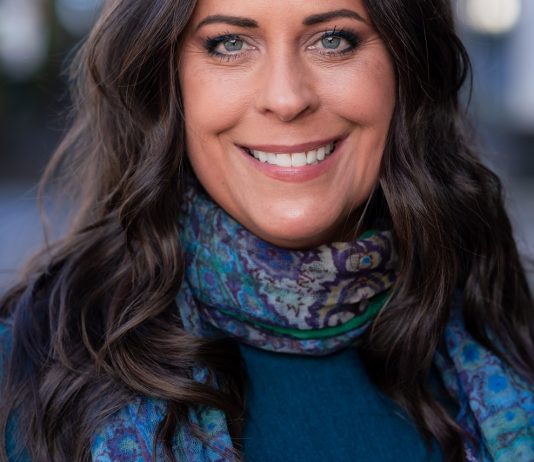 Maren Costa Builds Council Run on West Seattle Roots and Climate Organizing Maren is smiling and wearing a blue scarf.