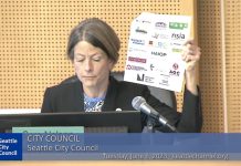 Seattle Council Narrowly Rejects ‘War on Drugs’ Bill Nelson displays a letter showing the logo of several busines sgroups including the Chamber, Downtown Seattle Association, NAOIP, and others.