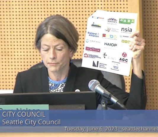 Seattle Council Narrowly Rejects ‘War on Drugs’ Bill Nelson displays a letter showing the logo of several busines sgroups including the Chamber, Downtown Seattle Association, NAOIP, and others.