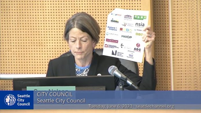 Nelson displays a letter showing the logo of several busines sgroups including the Chamber, Downtown Seattle Association, NAOIP, and others.
