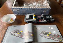 Welcome to Summer. Break Out the Legos. Partially built lego car with open instructions and a box full of bags of legos.