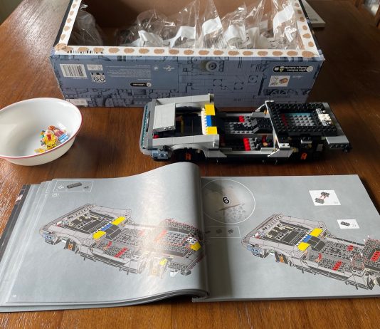 Welcome to Summer. Break Out the Legos. Partially built lego car with open instructions and a box full of bags of legos.