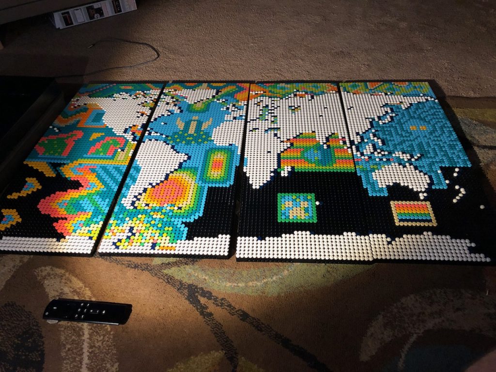 Unfinished Lego world map with black space instead of an Indian Ocean and varied colorful patterns through the rest of the oceans.