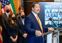 Harrell’s Office Buries Records Pertaining to Investigation into Chief of Staff Harrell stands at a lectern with a grin. His deputy mayors and Burgess wear masks.