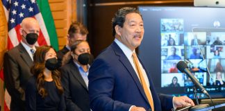 Harrell’s Office Buries Records Pertaining to Investigation into Chief of Staff Harrell stands at a lectern with a grin. His deputy mayors and Burgess wear masks.