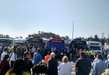 Metro Gears Up To Tackle Its Worker Shortage King County Executive Dow Constantine speaks at a podium in front of a row of busses flanked by Metro employees.