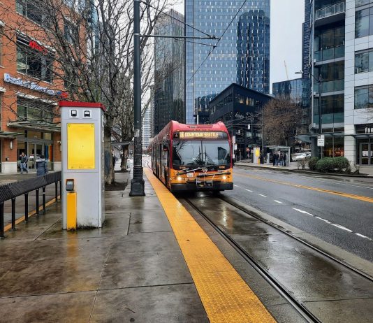 Harrell Advances New Denny Station Options That Could Delay Ballard Link A RapidRIde C bus pulls up to the transit stop in front of Whole Foods at Denny Way intersection on a wet afternoon.