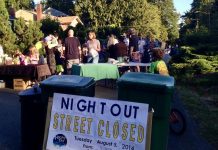 National Night Out Brings Neighbors (Briefly) Out on the Street A sign reads Night Out street closed with people gathered behind it socializing.
