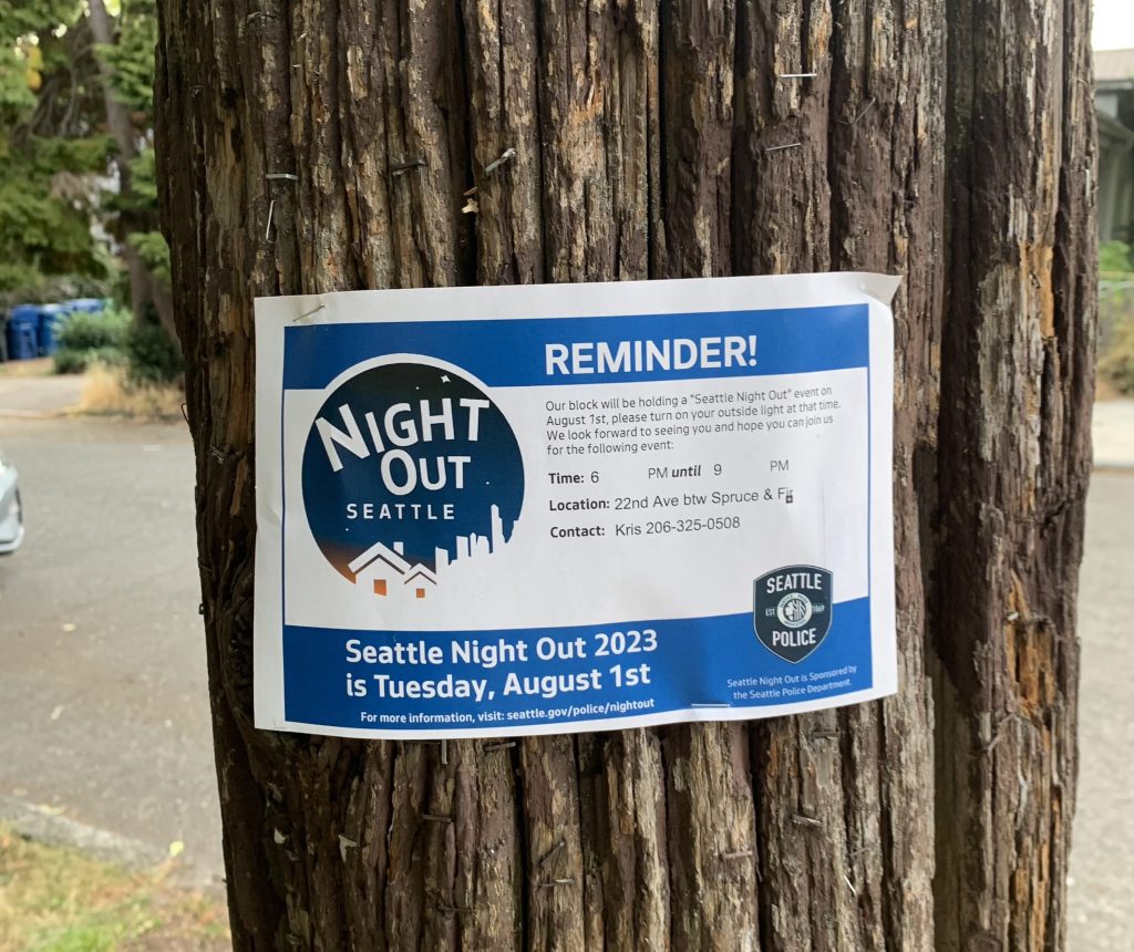 A telephone post has an reminder for Seattle Night Out 2023.
