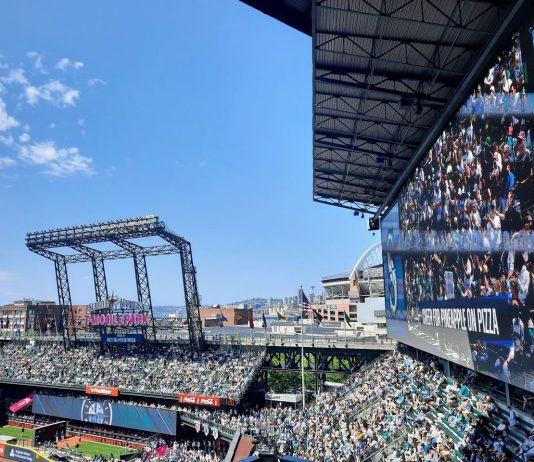 Good Urbanism, not Event Surges and Quick Fixes Will Spur Downtown Recovery The outfield bleachers at T Mobile Park with the skyline and blue skies in the background.