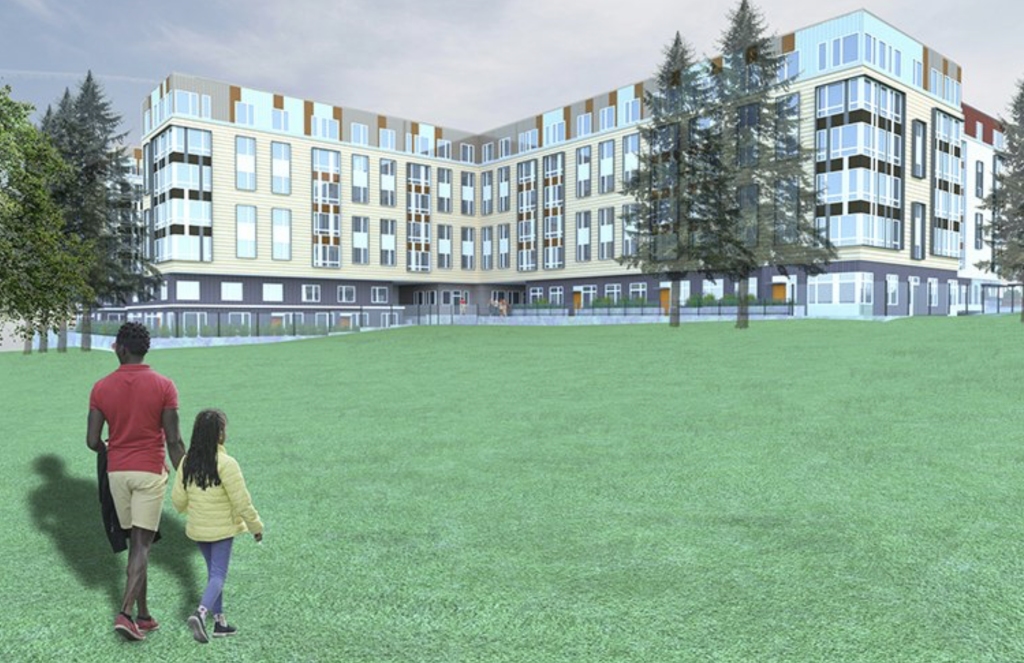 A man and girl walk in a green field in front of a modern multi-family building near trees.