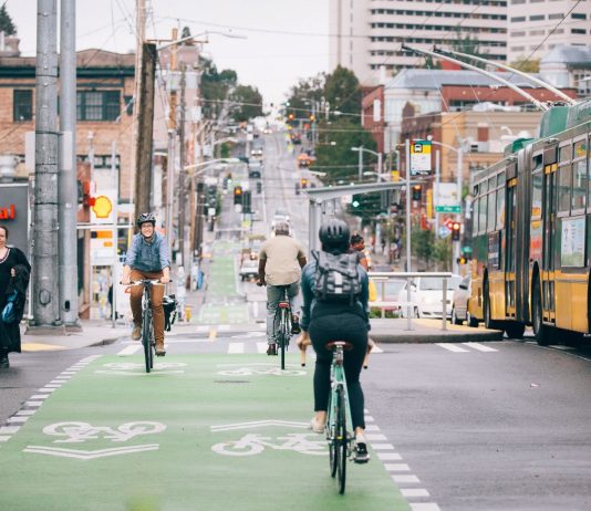 Seattle Lays Out 2030 Mode Shift Goals in Climate Framework People ride bikes along Broadway. The bustling business district in Capitol Hill blends bike lanes, pedestrian spaces, bus service, streetcar tracks, and vehicle traffic.
