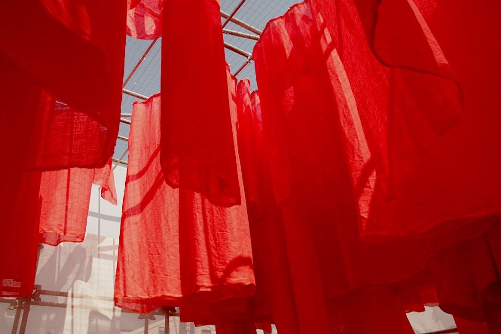 Hanging red curtain like fabric representing a city grid with hotter areas.