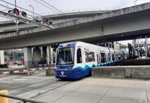 Sound Transit Decreases Link Frequencies to 20 Minutes Through August 20 for Repair Work A light rail train in SoDo passes under highway overpasses and enters an intersection.