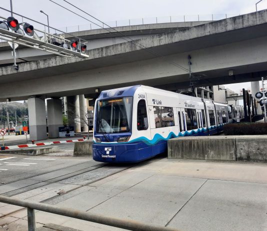 Sound Transit Delays Link Repairs, Schedules New Disruptions in Early 2025 A light rail train in SoDo passes under highway overpasses and enters an intersection.