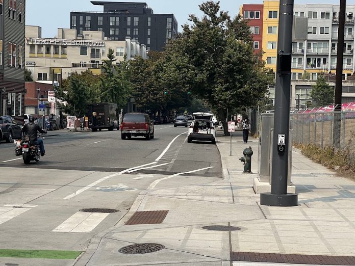 Looking down Western Avenue at a white car in the bike lane.