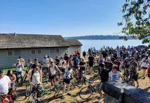 Two Hundred Plus Turn Out for Urbanist Bike Ride on Lake Washington Boulevard A crowd of more than 100 bicyclists assembled with Lake Washington in the background.