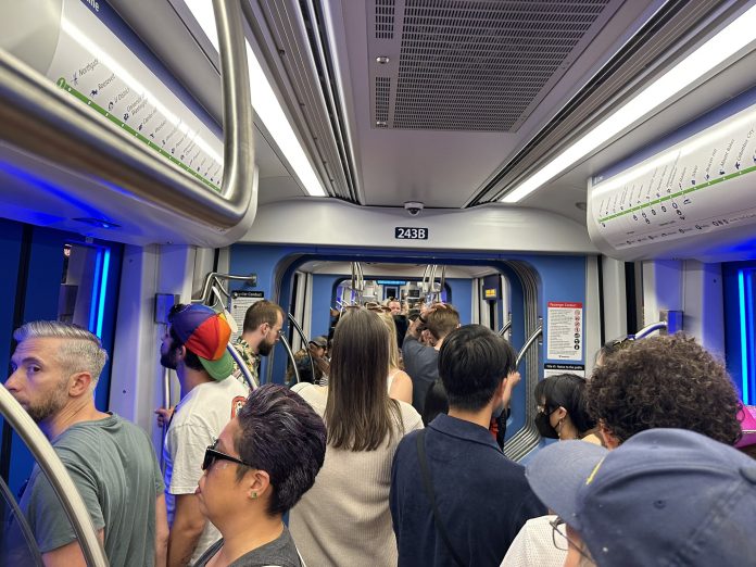 Crowds waiting at a light rail transit station.