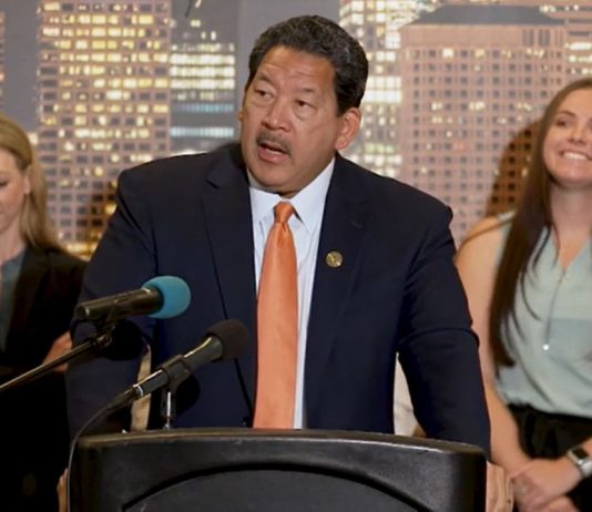 Harrell’s 2024 Budget Leaves Big Questions on Safety and Looming Shortfall Mayor Harrell at a podium with people behind him. He is talking about funding programs for the homeless.