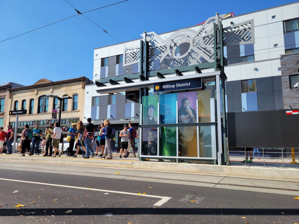 Sunny opening day of the T-Line with people waiting for a streetcar to arrive.