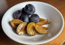The Grandeur of Seattle’s Tiny Plums Purple skin, yellow fruit plums in a white bowl.