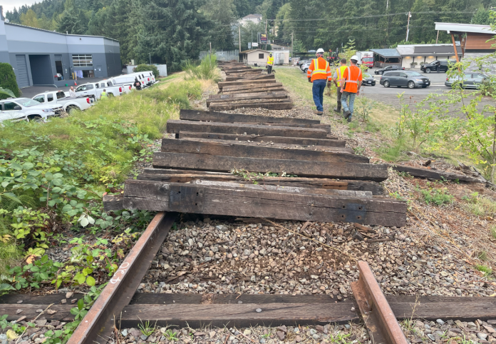 Looking down an abandoned railroad with wooden ties being removed.