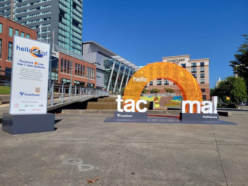 Temporary signs with T-Line info and a place to stand under an orange letter "O" to take a picture.