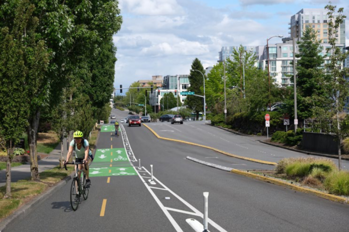 image-23 Looking down NE 12th Street with a rendering of a cycletrack with painted lines, green painted boxes and flexible posts.