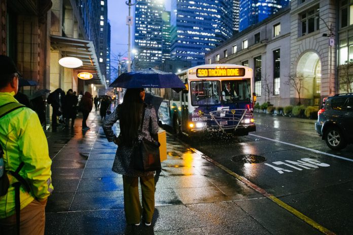A rainy downtown Seattle street scene with bus 590 approaching.