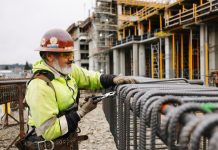 Sound Transit Prepares to Hire Three Megaproject Czars and Implement Other Expert Advice A construction works cuts rebar with the elevated station structure in the background.