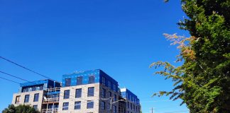 A five-story mixed-use brick building under construction on Phinney Avenue.