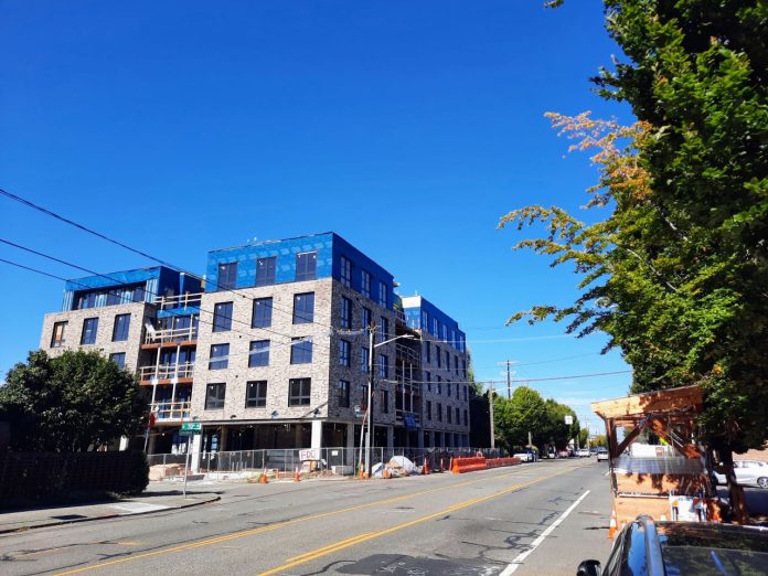 A five-story mixed-use brick building under construction on Phinney Avenue.