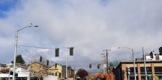 Op-Ed: The Seattle Police Department Has an Efficiency Problem Two police SUVs are parked behind metal barricades blocking traffic from Market Street.
