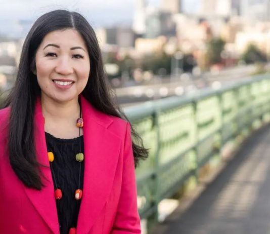 Seattle Council Appoints Morales Challenger Tanya Woo to Fill-In Council Seat Woo poses on the Jose Rizal Bridge with the iconic green railing and Seattle skyline in the background.